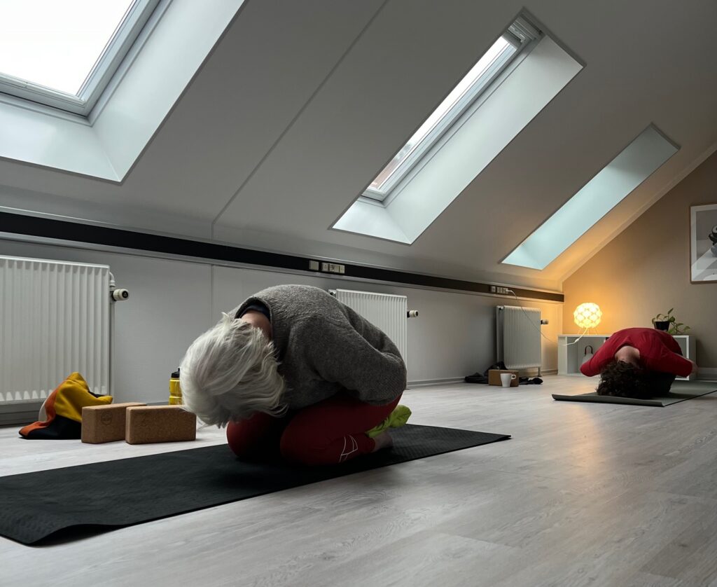 Fra en yin yoga time i Esbjerg, Kirkegade, hvor bedstemor på 78 år laver yoga i de hyggelige lokaler. Der er ovenlys vinduer og ro.