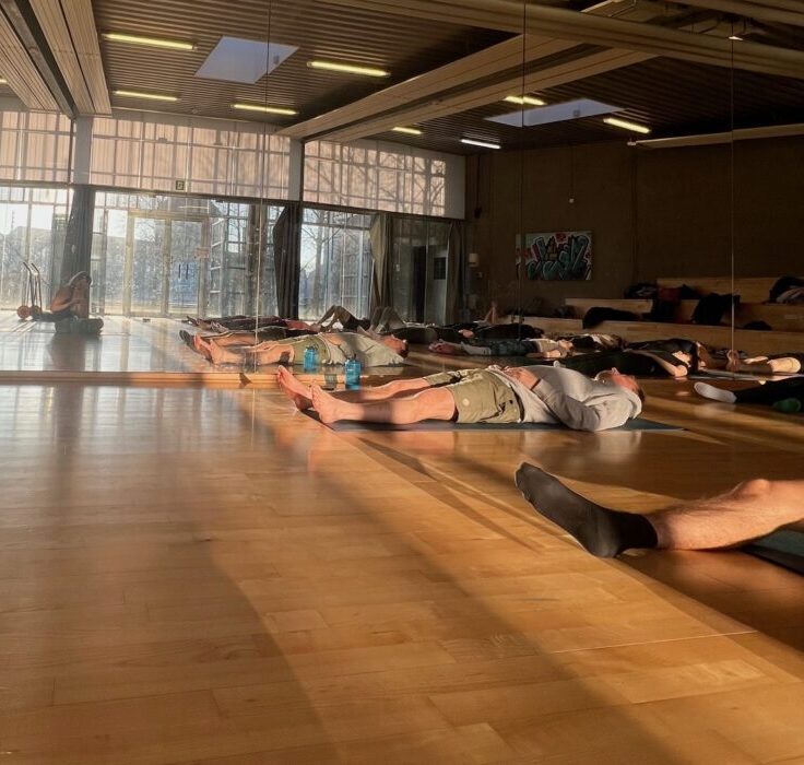 solen ses i som modskind i glasset, i GAMEs dansesal, som her bruges til Yoga hver torsdag, i Esbjerg. Der undervises på engelsk og mange studerende er med.