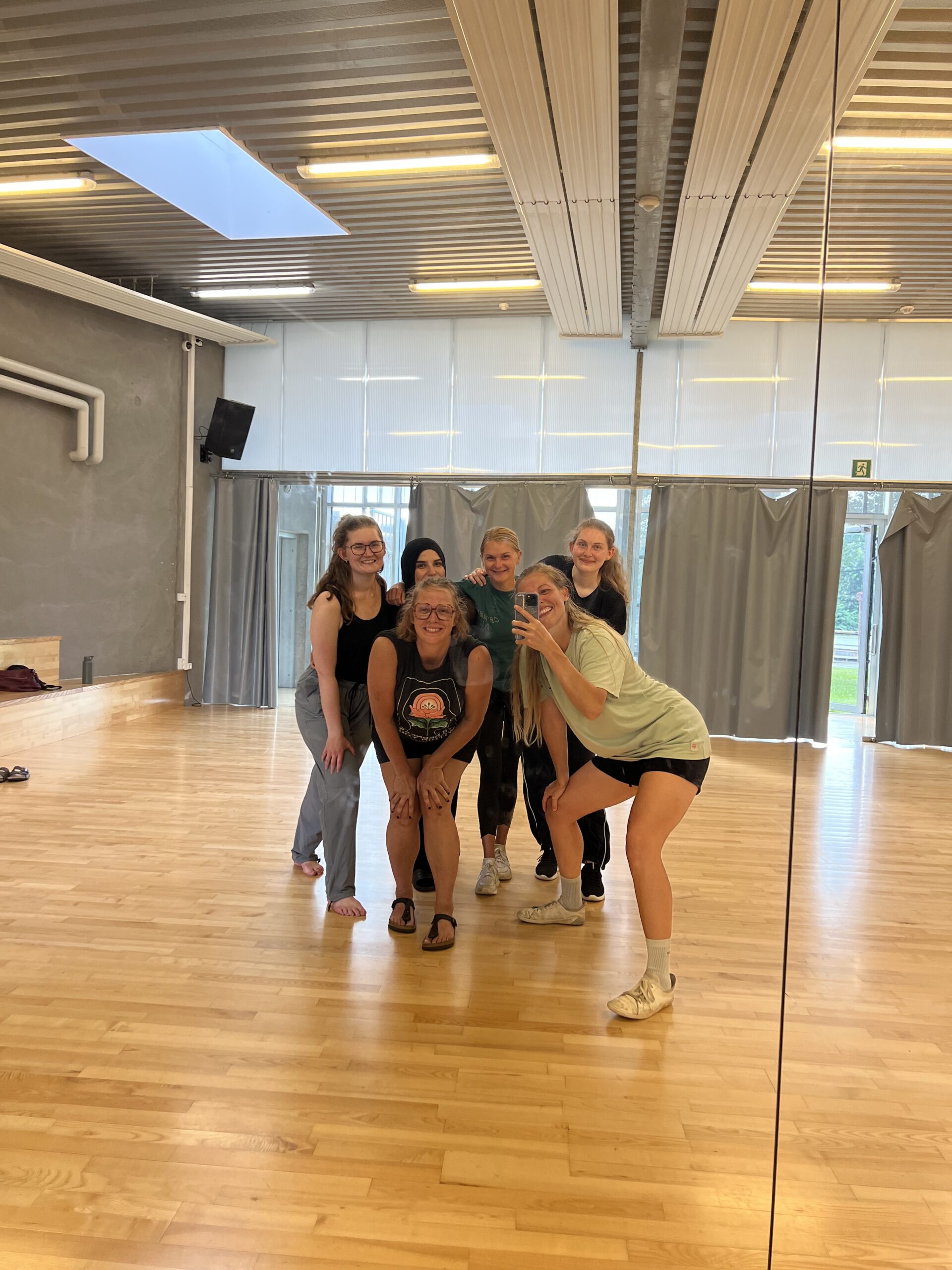 Dansere efter en hiphop workshop, står samlet i alle aldre, glade og svedige. billedet er taget ind i spejlet og der ses god energi og fællesskab blandt danserne i GAME streetmekka Esbjerg
